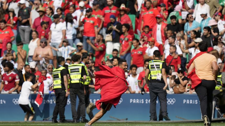 Morocco fans rush field during Olympic soccer opener vs Argentina. Game suspended, goal disallowed