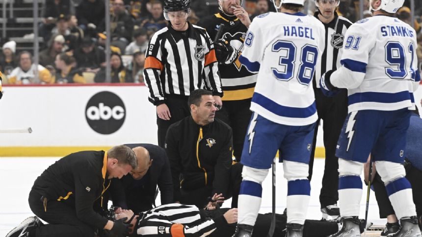 Referee Steve Kozari taken off ice on stretcher after collision with Lightning's Haydn Fleury